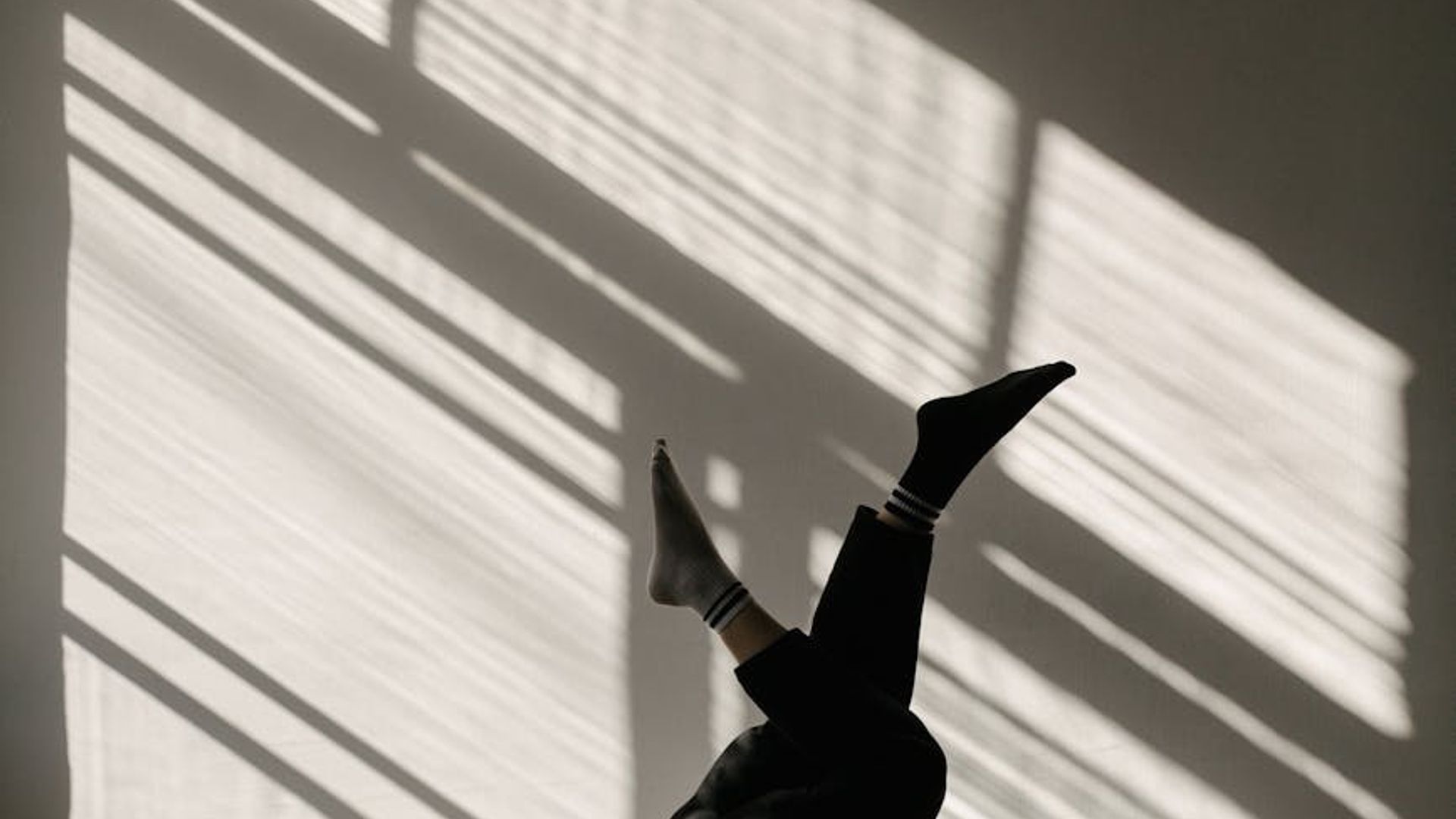 Atmospheric yoga studio with soft red lighting and shadows.