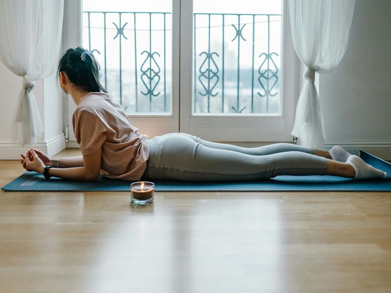 Minimalist yoga space with candles and a black mat.