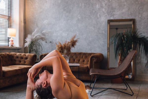 Person doing a slow flow yoga sequence on a dark mat.